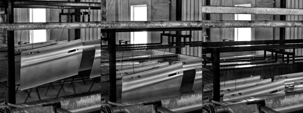 Gestelle mit Bauteilen in einer industriellen Beschichtungsanlage