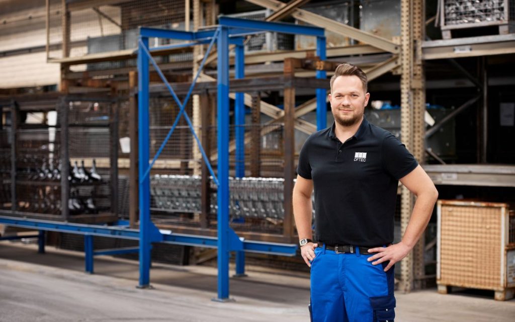Mitarbeiter vor Gestellbereich in einer industriellen Beschichtungsanlage