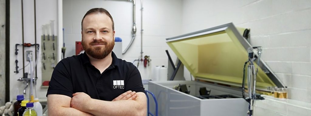 Mitarbeiter im Technikum vor einer Korrosionsprüfkammer