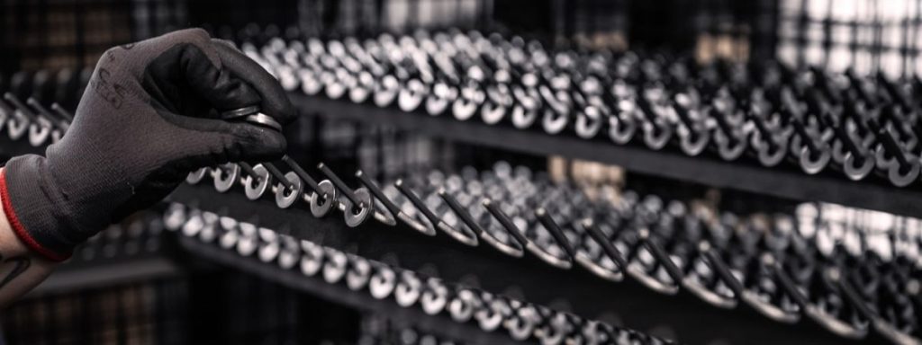 Bauteile im Sondergestell vor einer industriellen Beschichtungsanlage