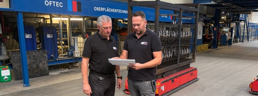 Mitarbeitende bei der technischen Abstimmung vor einer Beschichtungsanlage
