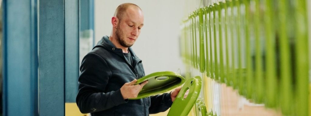 Mitarbeiter prüft Bauteile im Beschichtungsprozess als Grundlage für Verbesserungen